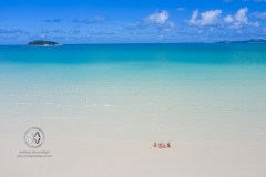 Sailing through the Whitsunday Islands to the white silica sands of Whitehaven Beach is a popular activity in Australia. Friends sit in the warm clear waters.