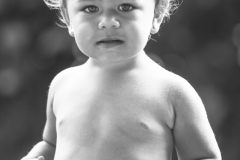 A 2 year old Hawaiian girl plays on the beach.