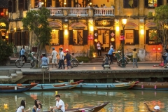Local boats on the Thu Bon River in Hoi An take passengers down the river at sunset.