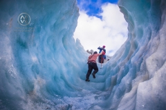 Travelers explore New Zealand's famous Franz Josef Glacier. Blue Ice, deep crevasses, caves and tunnels mark the ever changing ice.