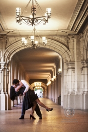 A couple embraces and dances in the middle of a beautiful hallway at Balboa Park in San Diego, California.