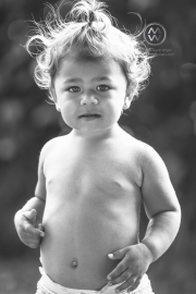 A 2 year old Hawaiian girl plays on the beach.