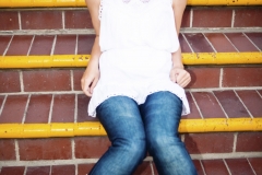 A high school girl poses for portraits at the Balboa Fun Zone in Newport Beach, California.