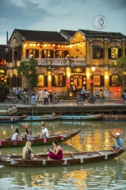 Local boats on the Thu Bon River in Hoi An take passengers down the river at sunset.