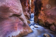 Hiking through the red rock slot canyons in Kanarraville, Utah.