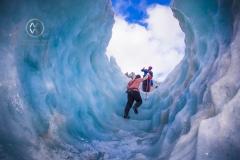 Travelers explore New Zealand's famous Franz Josef Glacier. Blue Ice, deep crevasses, caves and tunnels mark the ever changing ice.