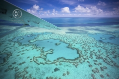 Aerial views over the Whitsunday Island chain and the Great Barrier Reef. Heart Reef is a popular sight from the sky.