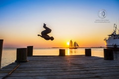 Waterplay off a waterfront dock in Utila at sunset in front of Trudy's Hotel.