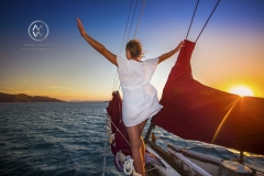 Sailing through the Whitsunday Islands is one of the most popular attractions in Australia. Passengers sit and watch the sunset descend over the ocean.