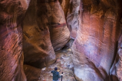Hiking through the red rock slot canyons in Kanarraville, Utah.